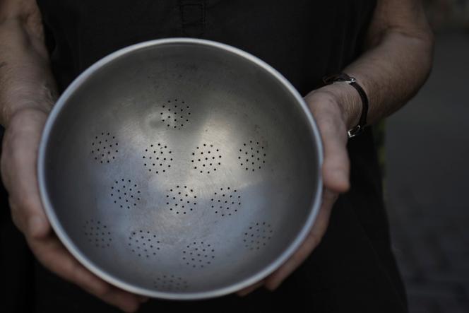 Un militant israélien brandit une passoire vide pour protester contre la famine qui touche les civils palestiniens dans la bande de Gaza, devant l’antenne de l’ambassade américaine à Tel Aviv, en Israël, le jeudi 24 juillet 2025.