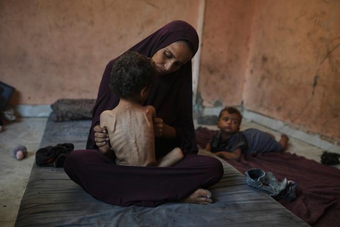 Naima Abu Ful tient dans ses bras son enfant de 2 ans, Yazan, souffrant de malnutrition, dans le camp de réfugiés de Shati, à Gaza, le 23 juillet 2025.