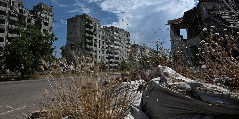 Un immeuble résidentiel endommagé par des attaques russes, et des filets anti-drones installés dans une rue de Orikhiv, dans l’oblast de Zaporijia, le 23 juille 2025. - STRINGER / REUTERS