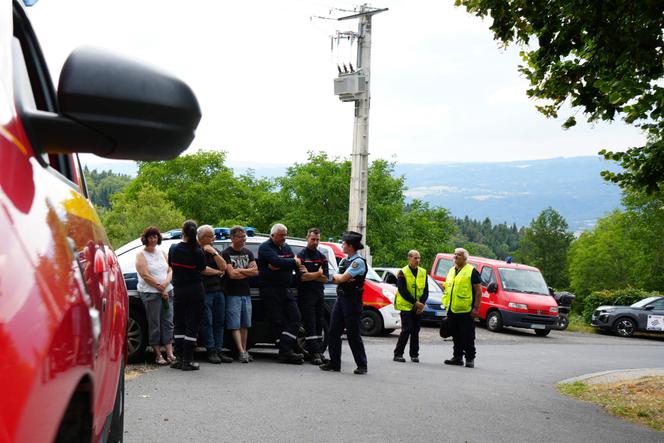 Emergency service personnel and a French gendarme stand by the roadside near the scene where spectators were killed after being hit by a car that veered off the road during an auto rally in Saint-Just, in France's Puy-de-Dome department, on July 26, 2025.