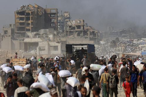 Des Palestiniens transportent des fournitures humanitaires entrées à Gaza via Israël, à Beit Lahya, dans le nord de la bande de Gaza, le 27 juillet 2025.
