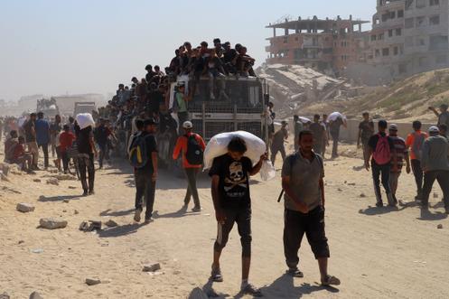 Des Palestiniens transportent de l’aide alimentaire entrée à Gaza via Israël, à Beit Lahya, dans le nord de la bande de Gaza, le 27 juillet 2025.