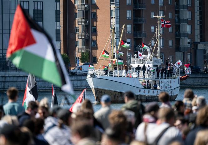 Des manifestants brandissant des drapeaux palestiniens regardent le bateau « Handala » arriver au port de Malmö, en Suède, le mercredi 8 mai 2024.