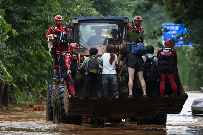 Des secouristes évacuent des résidents du village de Taishitun, dans le district de Miyun, en périphérie de Pékin, le 28 juillet 2025.