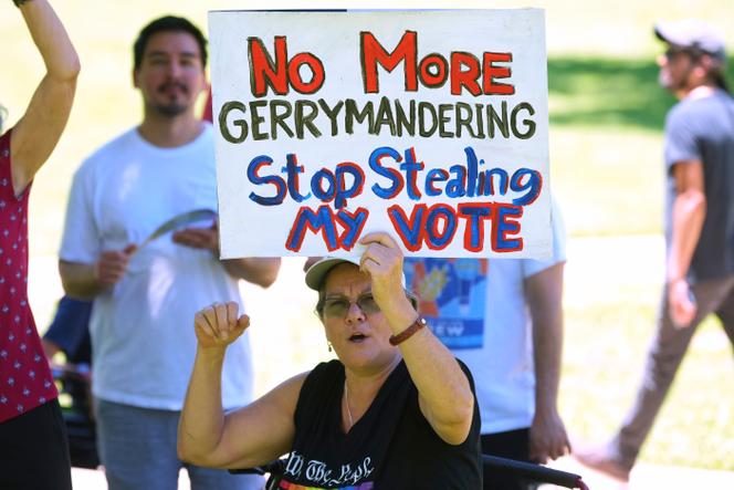 Une manifestante tient une pancarte « Stop au redécoupage électoral. Arrêtez de voler mon vote » lors d’un rassemblement devant le Capitole du Texas à Austin, le 24 juillet 2025.