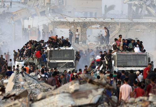 Des Palestiniens montent sur des camions transportant de l’aide humanitaire, à Beit Lahya, dans le nord de la bande de Gaza, le 29 juillet 2025.