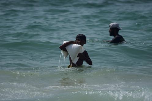 Un jeune Gazaoui porte un sac d’aide humanitaire qui a atterri dans la mer Méditerranée après avoir été largué par avion au-dessus du centre de Gaza, sur la côte d’Al-Zawayda, dans la bande de Gaza, mardi 29 juillet 2025.