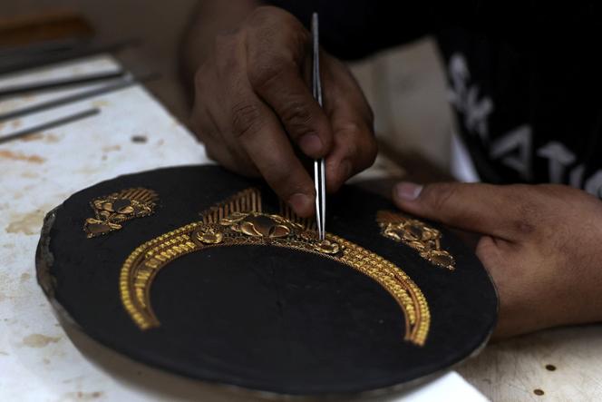 Un orfèvre travaille sur un collier en or dans un atelier à Ahmedabad (Inde), le 31 juillet 2025. 