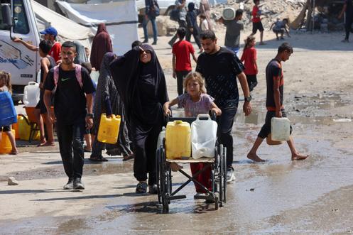 Des Gazaouis transportent des bidons d’eau potable à partir d’un point de distribution de la ville de Gaza, le 1ᵉʳ août 2025.