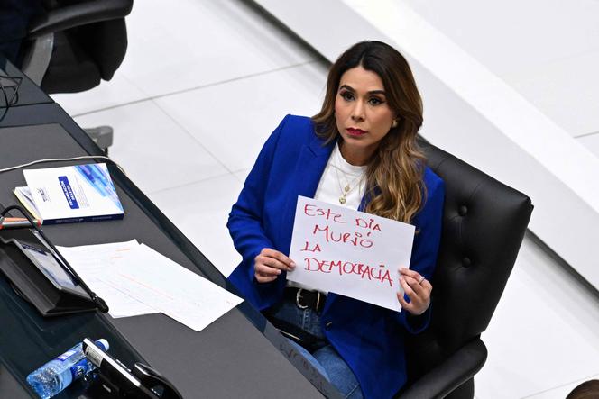 La députée du parti d’opposition, l’Alliance républicaine nationaliste (ARENA), Marcela Villatoro tient une pancarte sur laquelle est inscrit « La démocratie est morte aujourd’hui » lors d’une séance plénière du Congrès à San Salvador, le 31 juillet 2025.