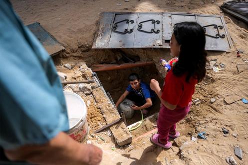 Un garçon remplit des récipients avec de l’eau qui reste dans les canalisations souterraines, à Beit Lahia, dans le nord de la bande de Gaza, le 24 avril 2025.
