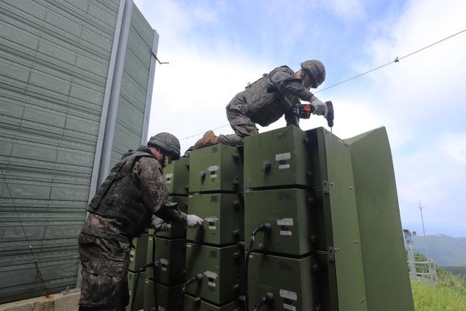 Cette photographie, diffusée par le ministère de la défense de Corée, montre des militaires coréens en train de démonter des haut-parleurs à la frontière avec la Corée du Nord, le 4 août 2025.