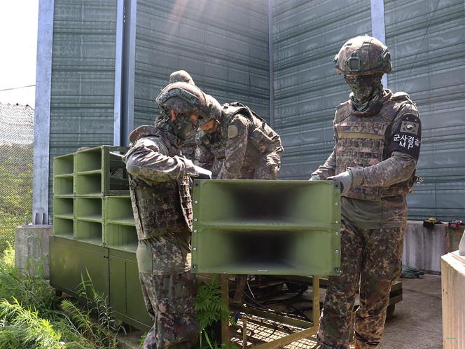 Des soldats sud-coréens en train de démonter des haut-parleurs, le 4 août 2025.