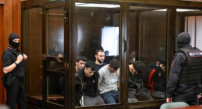 Um grupo de réus acusados de envolvimento no ataque de armas de 2024 na prefeitura da prefeitura de cutas da prefeitura que matou 149 pessoas entram em julgamento em Moscou em 4 de agosto de 2025.
