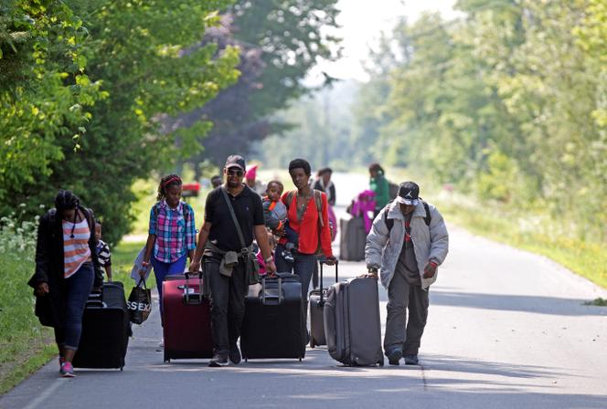 Des familles burundaises marchent en direction de la frontière entre les Etats-Unis et le Canada, à Champlain, dans l’Etat de New York, en août 2017.