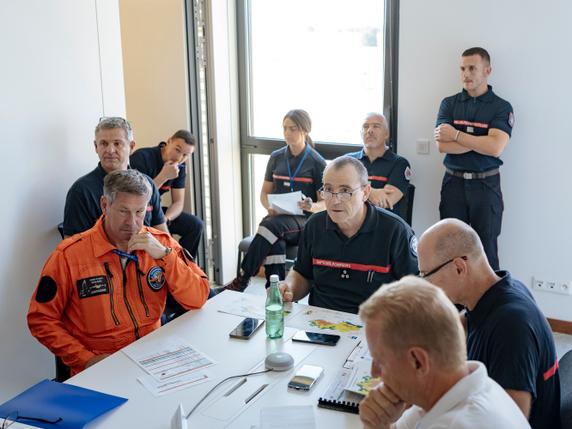 François Pradon, chef d’état-major de la Sécurité civile (au centre), assiste au briefing matinal quotidien, sur la base aérienne de Nîmes-Garons (Gard), le 8 août 2025.