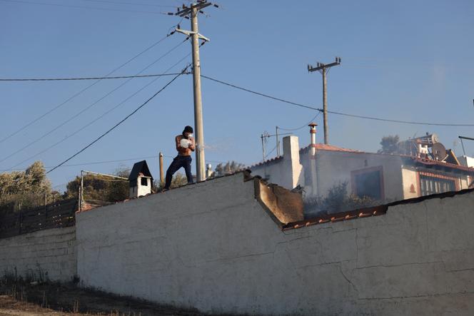 Un habitant de Keratea, près d’Athènes, tente d’éteindre un incendie, le 8 août 2025.