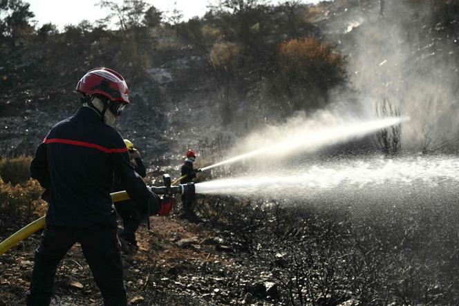 Des pompiers éteignent des braises, dans le massif des Corbières, le 9 août 2025.