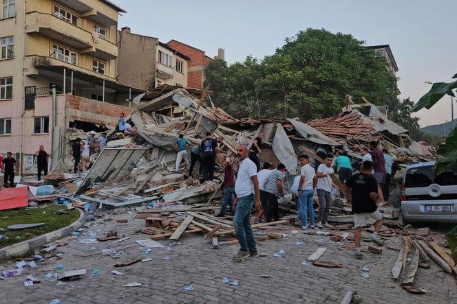 Des personnes déblayent les décombres d’un bâtiment effondré à la suite d’un tremblement de terre à Sindirgi, dans le nord-ouest de la Turquie, le dimanche 10 août 2025.