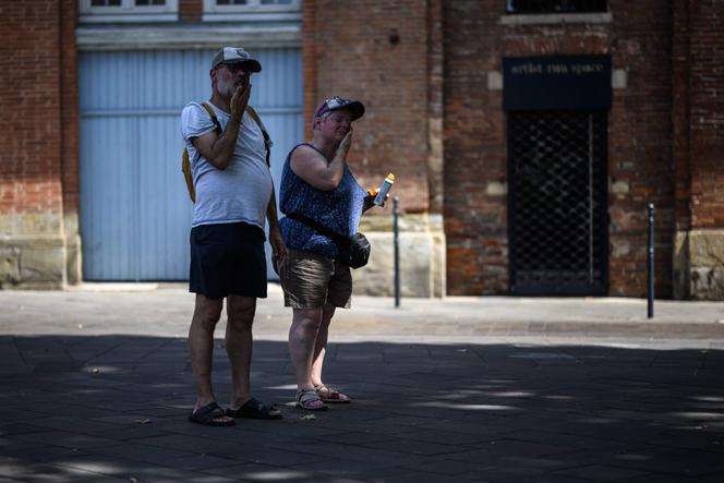 Un couple fait une pause à l’ombre pour mettre de la crème solaire sur les bords de la Garonne pendant une vague de chaleur à Toulouse, le 11 août 2025.