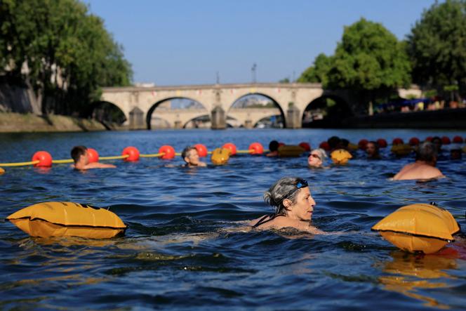 Des nageurs dans la Seine, sur le site de Bras-Marie alors qu’une vague de chaleur frappe la France, à Paris, le 12 août 2025. 