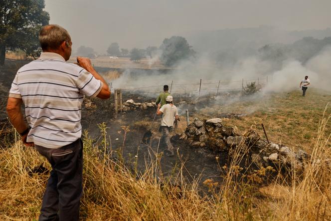 Les habitants tentent d’éteindre un feu, à Pareisas, dans le nord-ouest de l’Espagne, le 13 août 2025.