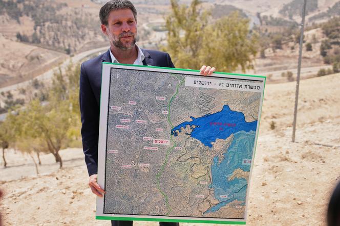Bezalel Smotrich, le ministre des finances israélien, montre une carte situant la future colonie E1, lors d’une conférence de presse à Maalé Adoumim, en Cisjordanie, le 14 août 2025.