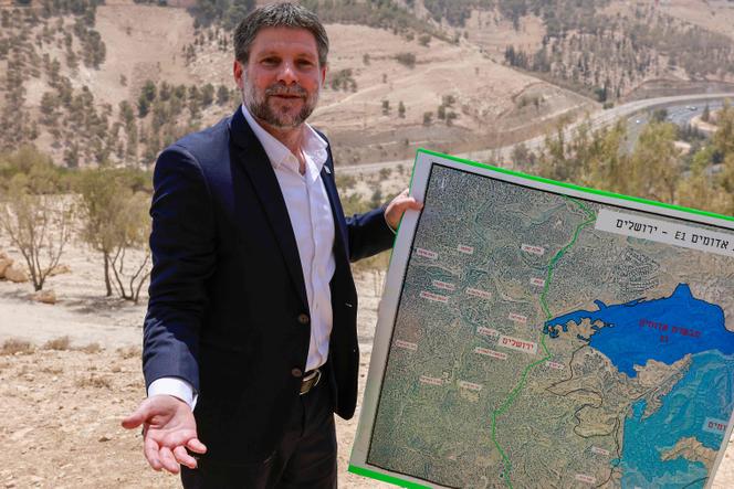 Le ministre des finances israélien, Bezalel Smotrich (extrême droite), brandit une carte d’une zone proche de la colonie de Maale Adumim, un corridor terrestre connu sous le nom de E1, situé aux abords de Jérusalem en Cisjordanie, le 14 août 2025, après une conférence de presse sur place. 