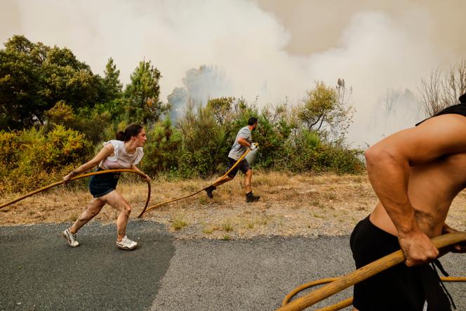 Des habitants de Larouco, dans le nord-ouest de l’Espagne, arrosent les abords de leur village, menacé par la progression d’un incendie, le 13 août 2025. 