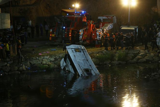 Tombé dans une rivière, un bus est remorqué par les secouristes, le 15 août 2025, dans le quartier El-Harrach d’Alger. 