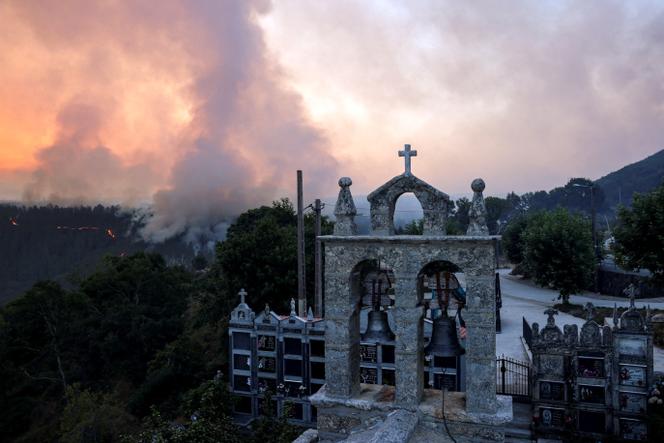De la fumée s’élève d’un incendie de forêt près d’un cimetière à As Fermosas, dans la province d’Orense, en Galice, Espagne, le 16 août 2025.