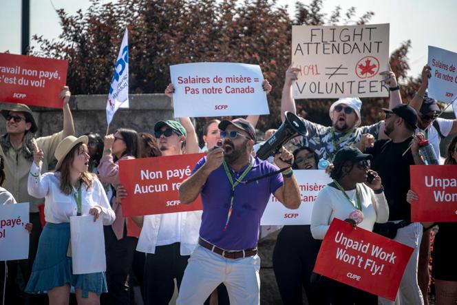 Des personnels navigants d’Air Canada brandissent des pancartes lors de la grève générale pour réclamer de meilleures rémunérations, à l’aéroport Pierre-Elliott-Trudeau de Montréal le 16 août 2025.