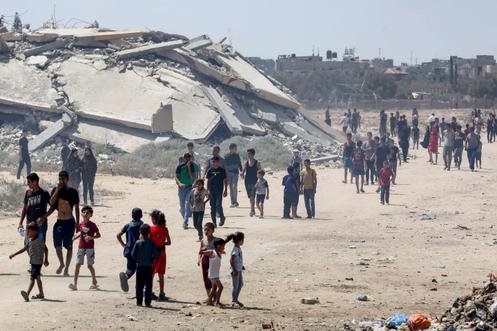 Ontheemde Palestijnen lopen naar de plek van een humanitaire hulppost bij het kamp Al-Bureij in het centrale deel van de Gazastrook, 17 augustus 2025.