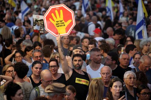 Een demonstrant houdt een spandoek vast met de tekst 