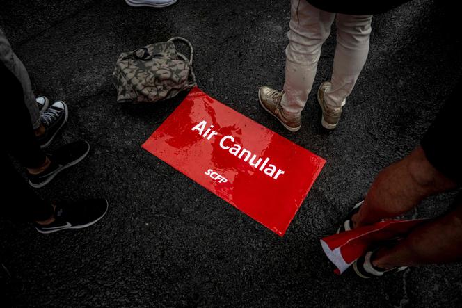 Un panneau détourné d’Air Canada lors d’une manifestation devant le siège d’Air Canada, à Montréal, le 17 août 2025.