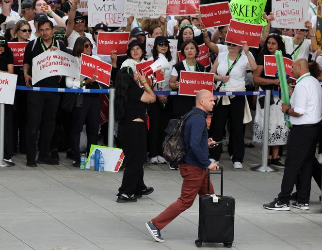 Des membres du personnel de bord d’Air Canada en grève à l’aéroport international de Vancouver à Richmond, en Colombie-Britannique, au Canada, le 18 août 2025. 