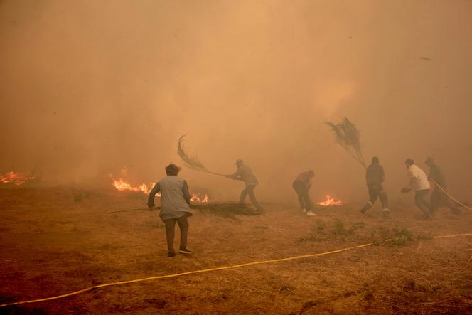Des habitants luttent contre un incendie qui progresse vers le village de Rebordondo, près d’Orense, dans le nord-ouest de l’Espagne, le lundi 18 août 2025. 