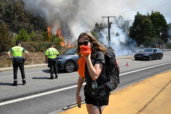Un feu de forêt aux abords d’une route, près du village de Mougas (Galice), en Espagne, le 22 août 2025.