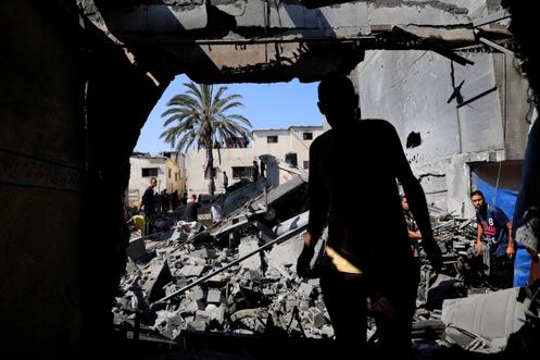 Palestijnen halen persoonlijke bezittingen op uit hun huis dat is verwoest door een Israëlisch bombardement in Deir Al-Balah, Gazastrook, 23 augustus 2025.
