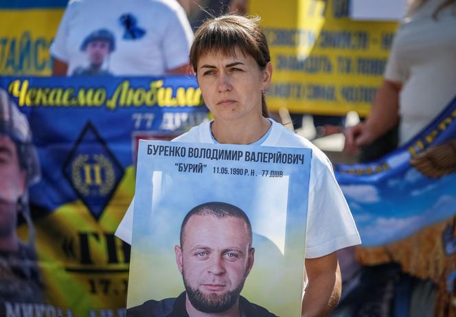 Une femme brandit le portrait d’un soldat ukrainien porté disparu, à l’occasion du Jour de l’Indépendance, à Kiev, le 24 août 2025.