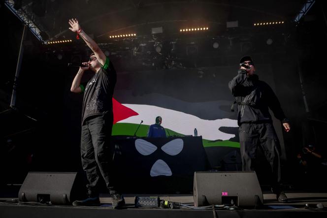 Le groupe nord-irlandais Kneecap se produit sur scène devant un drapeau palestinien sur un écran lors d’un concert au festival de musique Rock en Seine, à Saint-Cloud (Hauts-de-Seine), près de Paris, le 24 août 2025.