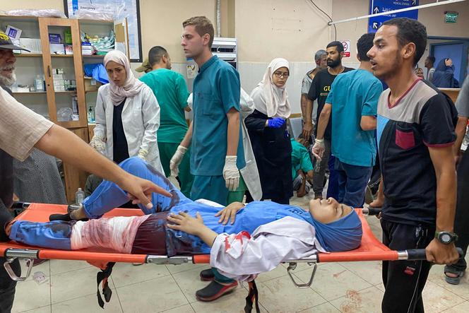 Des Palestiniens transportent une médecin blessée après les frappes israéliennes sur l’hôpital Nasser, à Khan Younès, dans le sud de la bande de Gaza, le 25 août 2025.