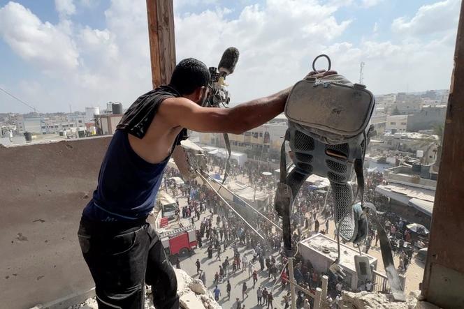 Un homme tient l’équipement utilisé par le caméraman palestinien Hussam Al-Masri, qui était sous contrat avec Reuters, sur le site où il a été tué avec d’autres journalistes et des civils lors des frappes sur l’hôpital Nasser, à Khan Younès, le 25 août 2025. 