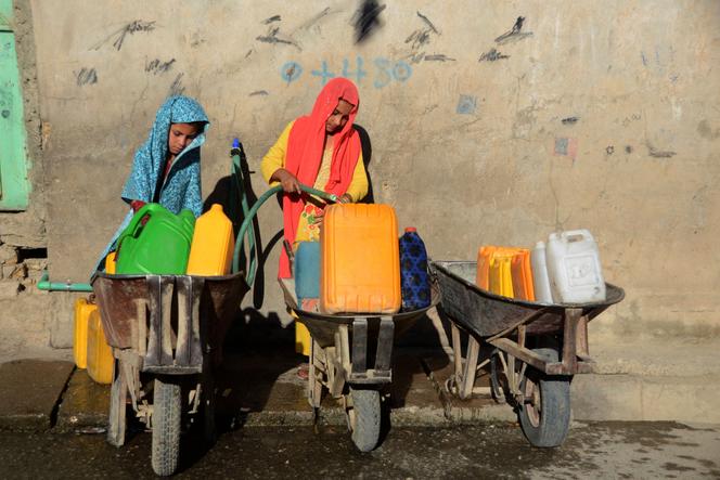 De jeunes filles remplissent des récipients d’eau potable en provenance d’un robinet, à Kandahar, dans le sud de l’Afghanistan, le 24 mai 2022.