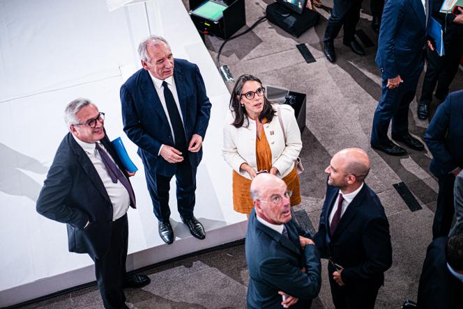 Le premier ministre, François Bayrou, entouré de son chef de cabinet, Pierre-Emmanuel Portheret, et de sa cheffe de cabinet adjointe, Adeline Savy, à l’issue de sa conférence de presse sur le budget 2026, à Paris, le 25 août 2025.