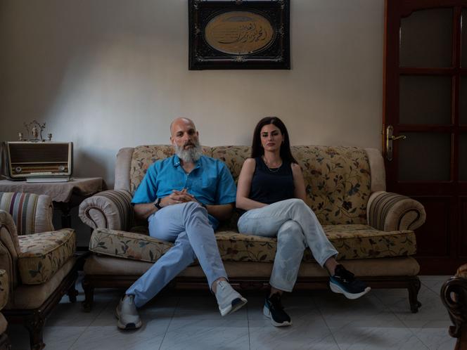 Alaa Ibrahim, un alaouite de 47 ans déplacé à Homs, et son épouse, Diana Mahfoud, dans le salon de leur maison, à Homs, en Syrie, le 18 juillet 2025.