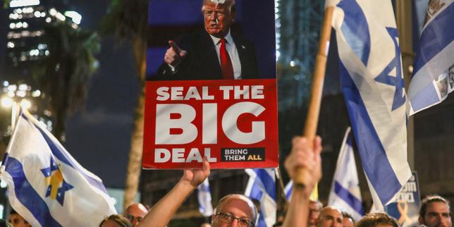 Un manifestant brandit une pancarte représentant le président américain, Donald Trump, lors d’une manifestation à Tel-Aviv pour exiger la fin immédiate de la guerre à Gaza et la libération de tous les otages, le 26 août 2025.