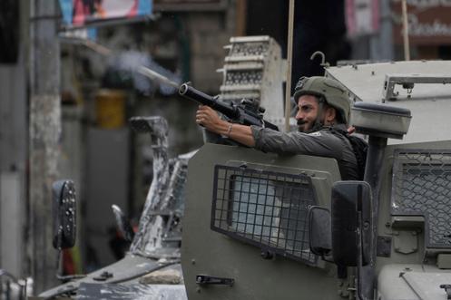 Un membre des forces de sécurité israéliennes tire des grenades lacrymogènes lors d’un raid militaire dans la ville de Naplouse, en Cisjordanie, le 27 août 2025.