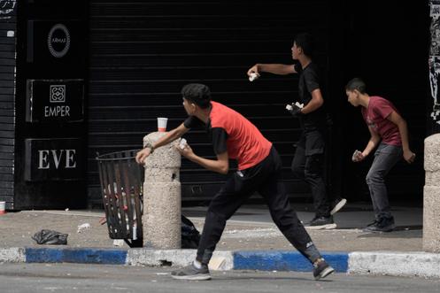 Des Palestiniens jettent des pierres sur les forces israéliennes, lors d’un raid militaire dans la ville de Naplouse, en Cisjordanie, le 27 août 2025.