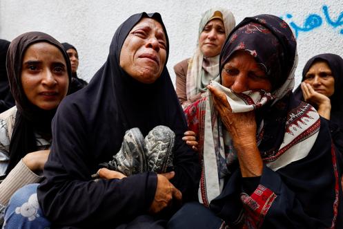 La mère d’un adolescent palestinien tué mercredi par des tirs israéliens tient ses chaussures lors de ses funérailles à l’hôpital Al-Shifa, dans la ville de Gaza, le 28 août 2025.
